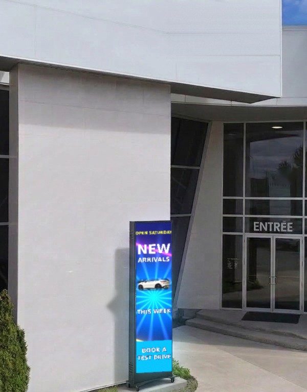 LED poster display on a wheeled stand at a business's glass entrance