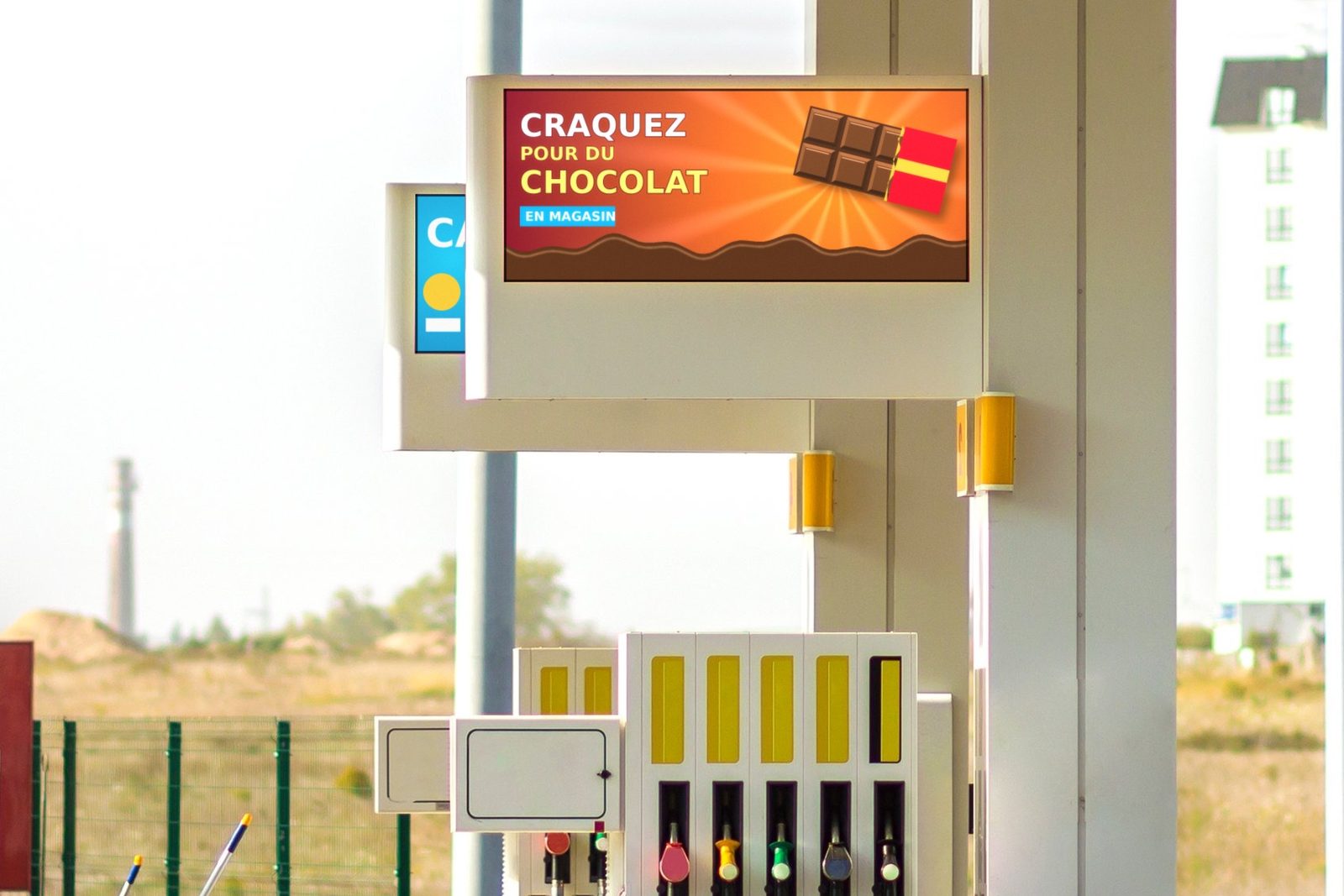 Écran DEL sur la marquise d’une station-service, au-dessus des pompes, qui annonce du chocolat en magasin