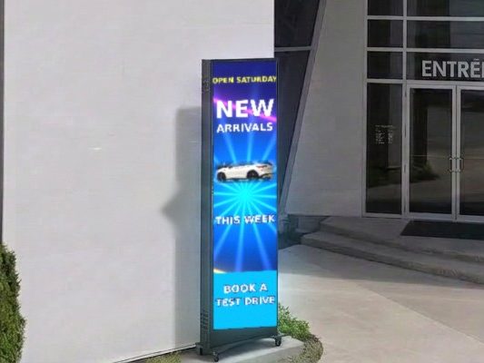 LED poster display on a wheeled stand at a business's glass entrance