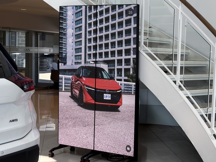 Deux affiches DEL intérieures sur pieds à roulettes dans la salle d’exposition d’un concessionnaire Nissan